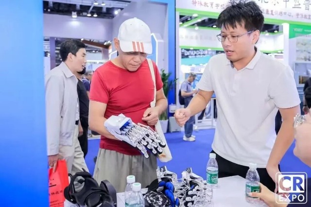于金须在博览会上向来宾介绍手部康复机器人 公司供图.jpg 于金须在博览会上向来宾介绍手部康复机器人 公司供图.jpg